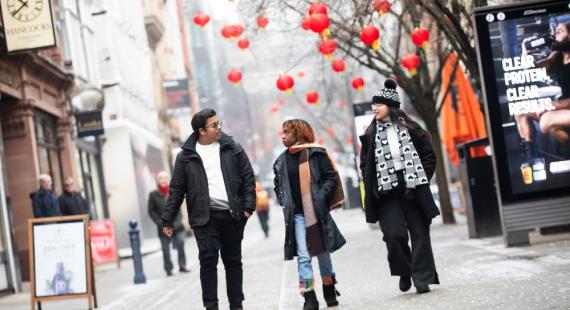 Three international students walking down King Street in Manchester
